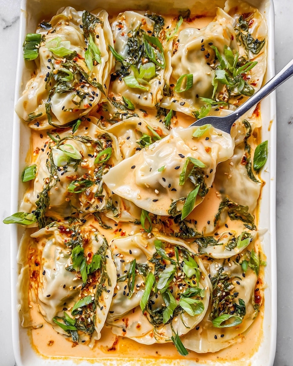 The image shows a white baking dish filled with three visual layers: the bottom layer is a spread of smooth, orange-colored sauce; on top of the sauce, there is a loose layer of fresh, bright green spinach leaves with long stems; the top layer consists of pale, semi-cooked dumplings with slightly crimped edges, arranged evenly over the spinach. The dish is placed on a white marbled surface with the edge of a red handle visible. photo taken with an iphone --ar 4:5 --v 7