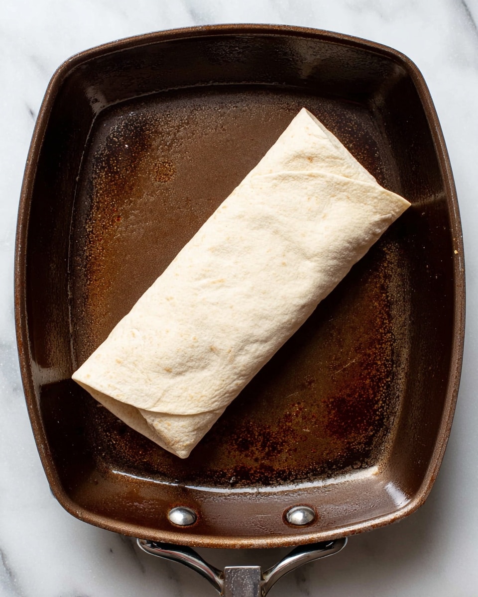 Three burritos with a golden-brown grilled outer layer are placed on a white plate. Each burrito is filled with grilled pieces of light brown chicken, green sauce, red tomato chunks, and fresh green cilantro, with the fillings visible at the open ends. There is some green sauce and tomato pieces spread around the plate, along with a wedge of lime showing its juicy light green inside. In the background, blurred green plants can be seen, and the plate rests on a white marbled surface with a turquoise cloth peeking out beneath it. Photo taken with an iphone --ar 4:5 --v 7