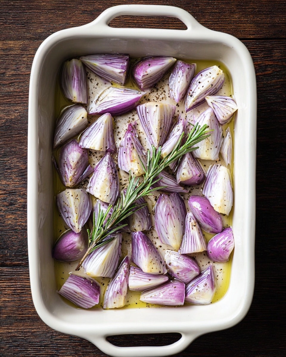 A raw, marinated meat roll covered with chopped herbs and garlic sits on a silver roasting pan with a metal rack inside. The steak is dark red and tied with kitchen string, showing a textured surface full of green herb bits. To the left of the pan on a white marbled surface, there are two halves of a purple shallot and two sprigs of rosemary with thin green leaves. Above the pan, there is a clear glass bowl with leftover marinade and a white brush resting inside. Photo taken with an iphone --ar 4:5 --v 7