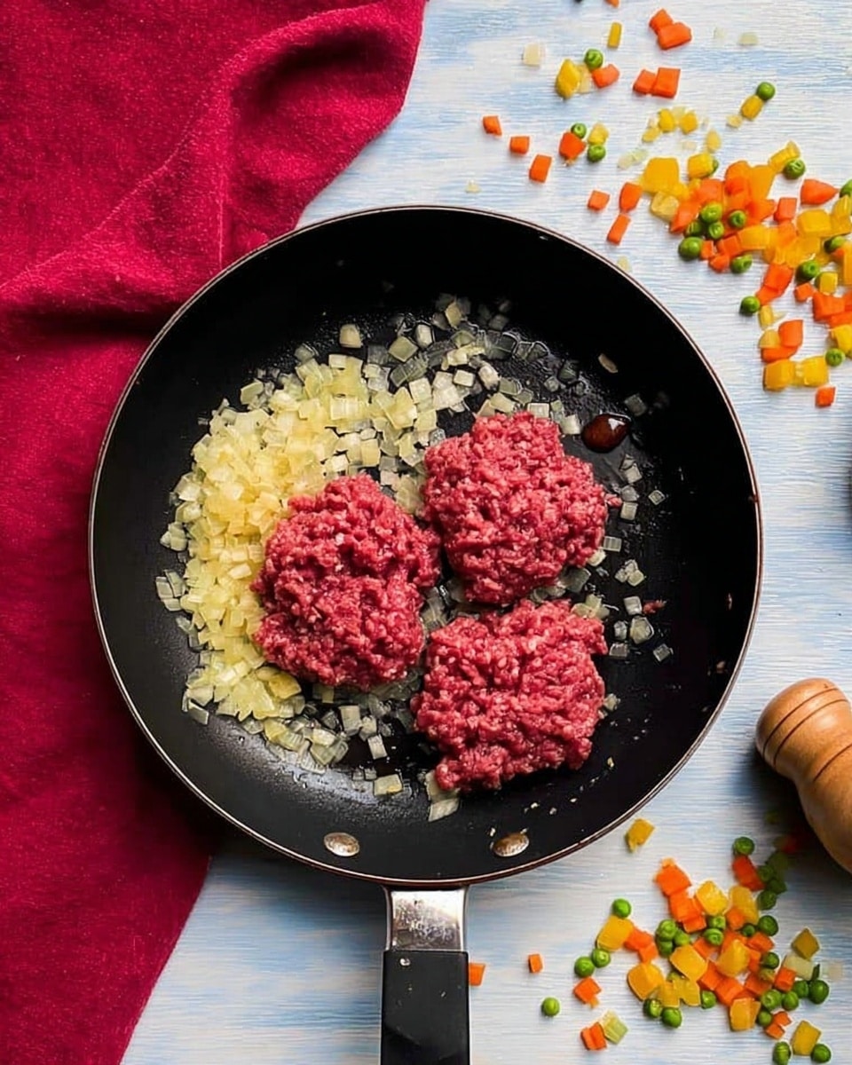 A clear square glass dish placed on a white marbled surface holds a two-layered dish. The bottom layer fills most of the dish with a mix of finely chopped vegetables including green peas, orange carrots, yellow corn, and ground meat with a brown color and crumbly texture. The top layer is thick mashed white potatoes being spread over the vegetables with a wooden spoon held by a woman's hand from the right side. Small scattered vegetable pieces and a pepper grinder are seen nearby, along with part of a red cloth in the upper left corner. photo taken with an iphone --ar 4:5 --v 7
