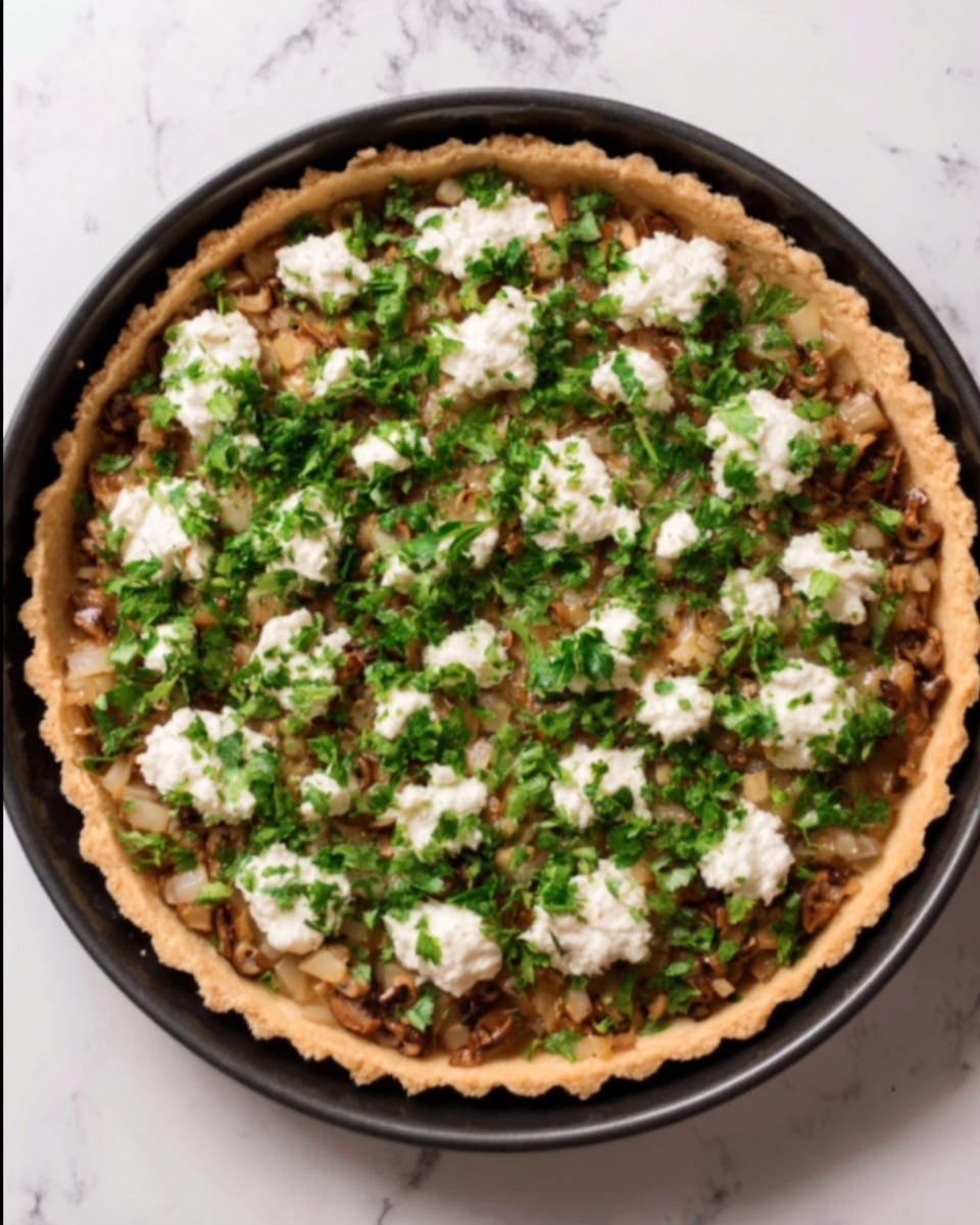 The image shows a round pie with a golden brown crust in a black tart pan. Inside the pie, the first visible layer is a mix of finely chopped mushrooms and onions, cooked to a soft brown color. On top of this mixture, there is a spread of fresh green chopped parsley scattered evenly. Small dollops of white cheese are placed on the parsley layer, creating a contrast in color and texture. The pie is set on a white marbled surface. photo taken with an iphone --ar 4:5 --v 7