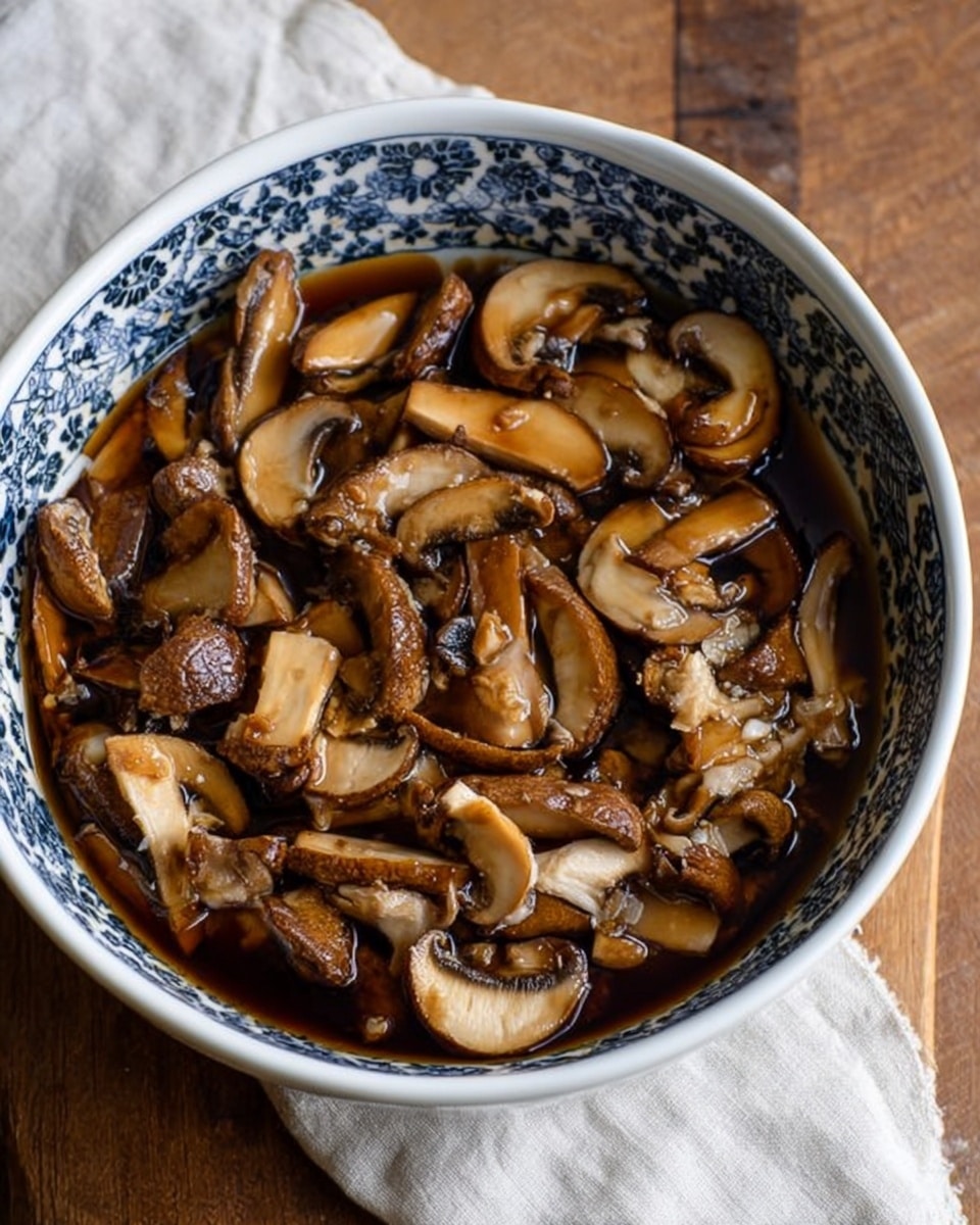 A white bowl with a blue pattern around the rim is filled with many pieces of brown mushrooms soaking in dark brown liquid. The mushrooms are sliced in different sizes, some showing smooth caps and others showing textured stem sections. The bowl is placed on a wooden surface with a white cloth in the background. The mushrooms look soft and wet, floating in the liquid that fills the bowl nearly to the edge. photo taken with an iphone --ar 4:5 --v 7