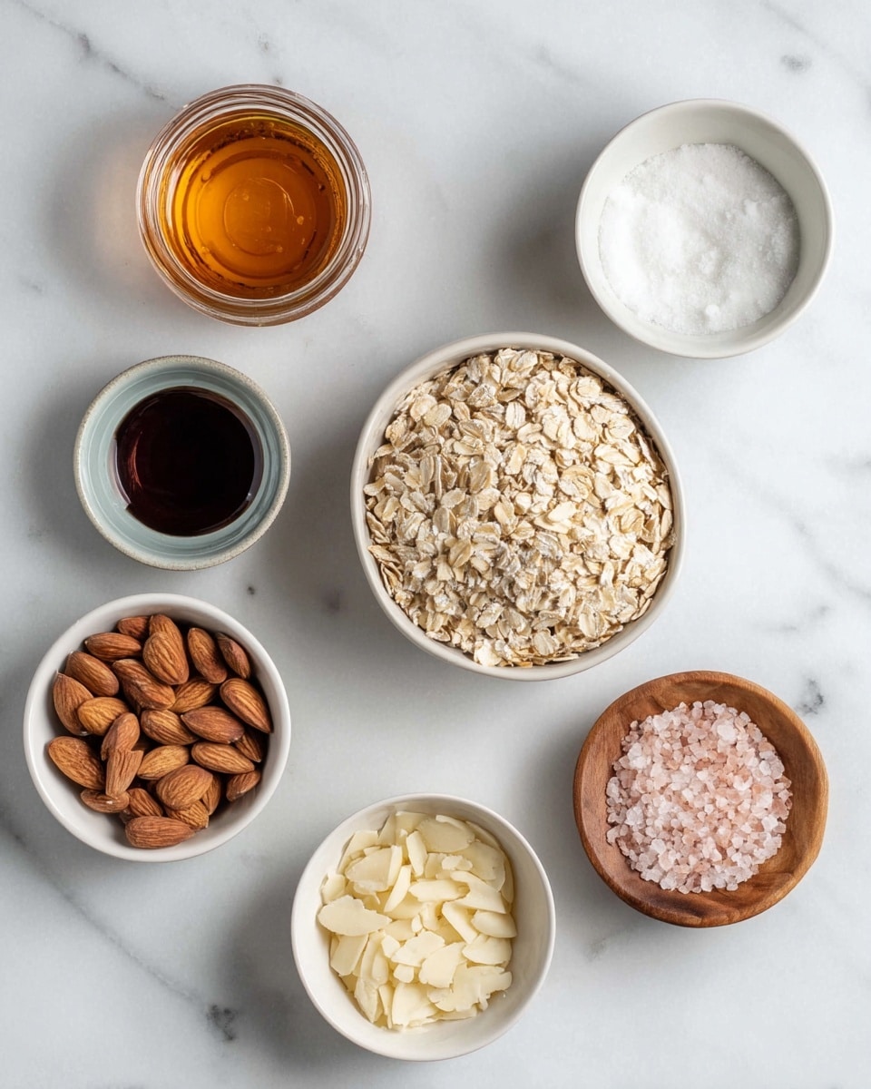 A white bowl filled with creamy white yogurt at the bottom, topped with a thick layer of golden-brown granola mixed with whole almonds and crunchy oats, and bright red raspberries placed on one side. A shiny gold spoon is inside the bowl, resting on the granola. In the background, there is a tray with more granola and another white bowl filled similarly with yogurt, granola, and raspberries. The setting is on a white marbled surface with small white dishes containing raspberries and sliced almonds nearby. Photo taken with an iphone --ar 4:5 --v 7