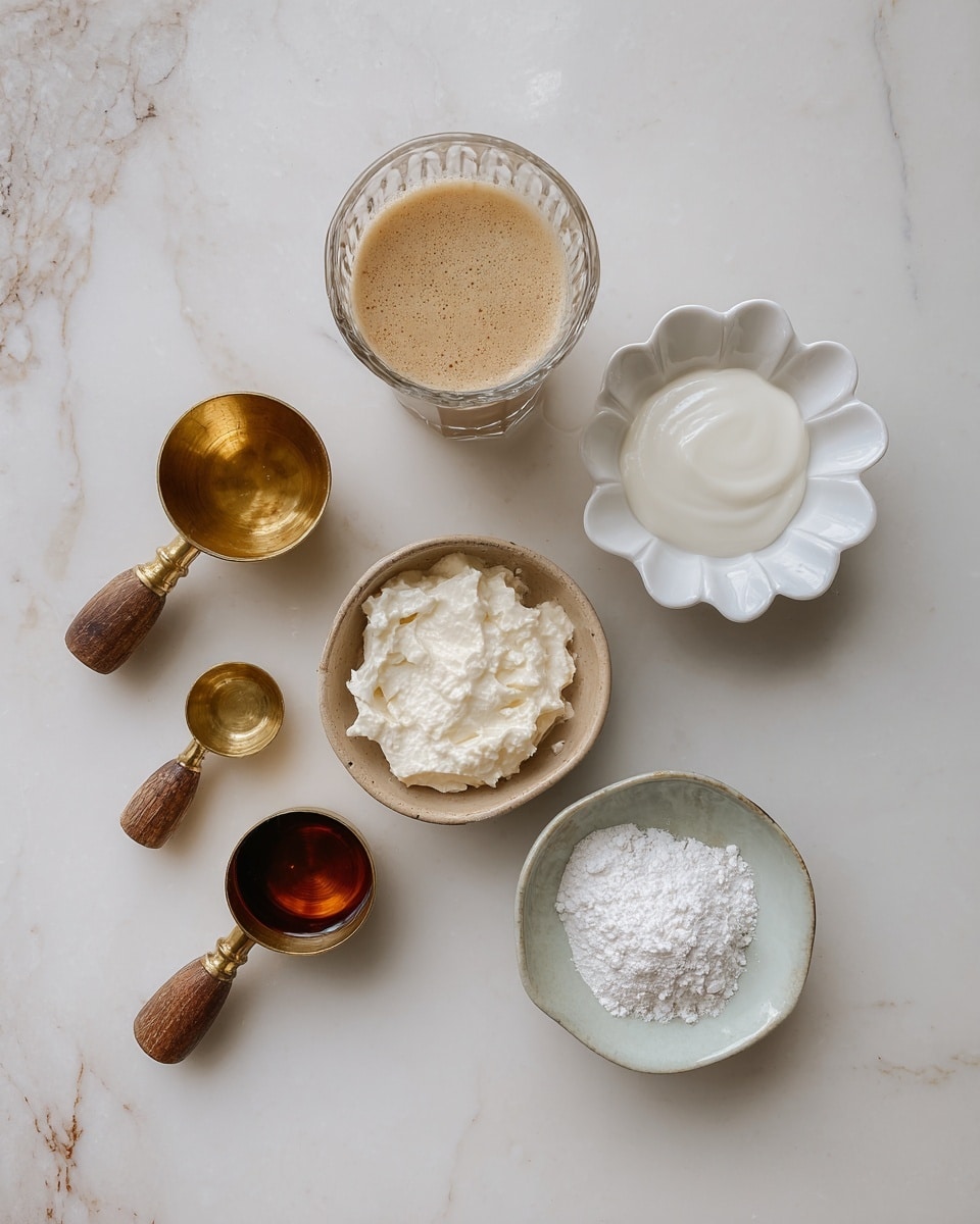 A tall clear glass filled with a creamy light brown coffee drink topped with a thick layer of white whipped cream, sprinkled generously with dark brown cocoa powder that spreads slightly over the edges. The glass sits on a white marbled surface dusted with more cocoa powder. Two vintage silver spoons lie crossed beside the glass. In the background, there is a small white bowl with loose cocoa powder and a metal strainer resting on it, along with some light-colored biscuits partially visible. Photo taken with an iphone --ar 4:5 --v 7