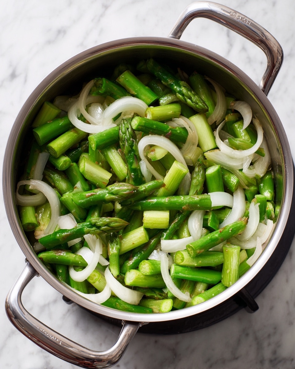 A shiny large silver pot is filled with chopped green asparagus pieces and white onion rings mixed together. The asparagus is cut into short sections showing a fresh green color, while the onion pieces are white and slightly thick, scattered evenly throughout the pot. The pot is on a stove with a white marbled surface around it, and the pot handles are silver and shiny. photo taken with an iphone --ar 4:5 --v 7