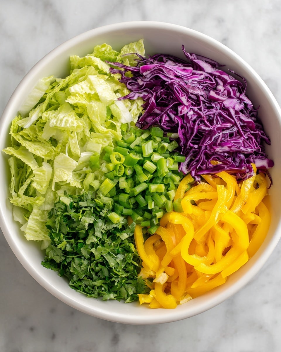 A white bowl filled with chopped green lettuce forming a base layer on one side and shredded purple cabbage piled on top nearby; in the next image, the bowl has more layers added on the lettuce side including chopped light green scallions, chopped fresh green herbs, thin orange pepper rings, and thin yellow pepper rings, all layered neatly next to each other, sitting on a white marbled surface. Photo taken with an iphone --ar 4:5 --v 7