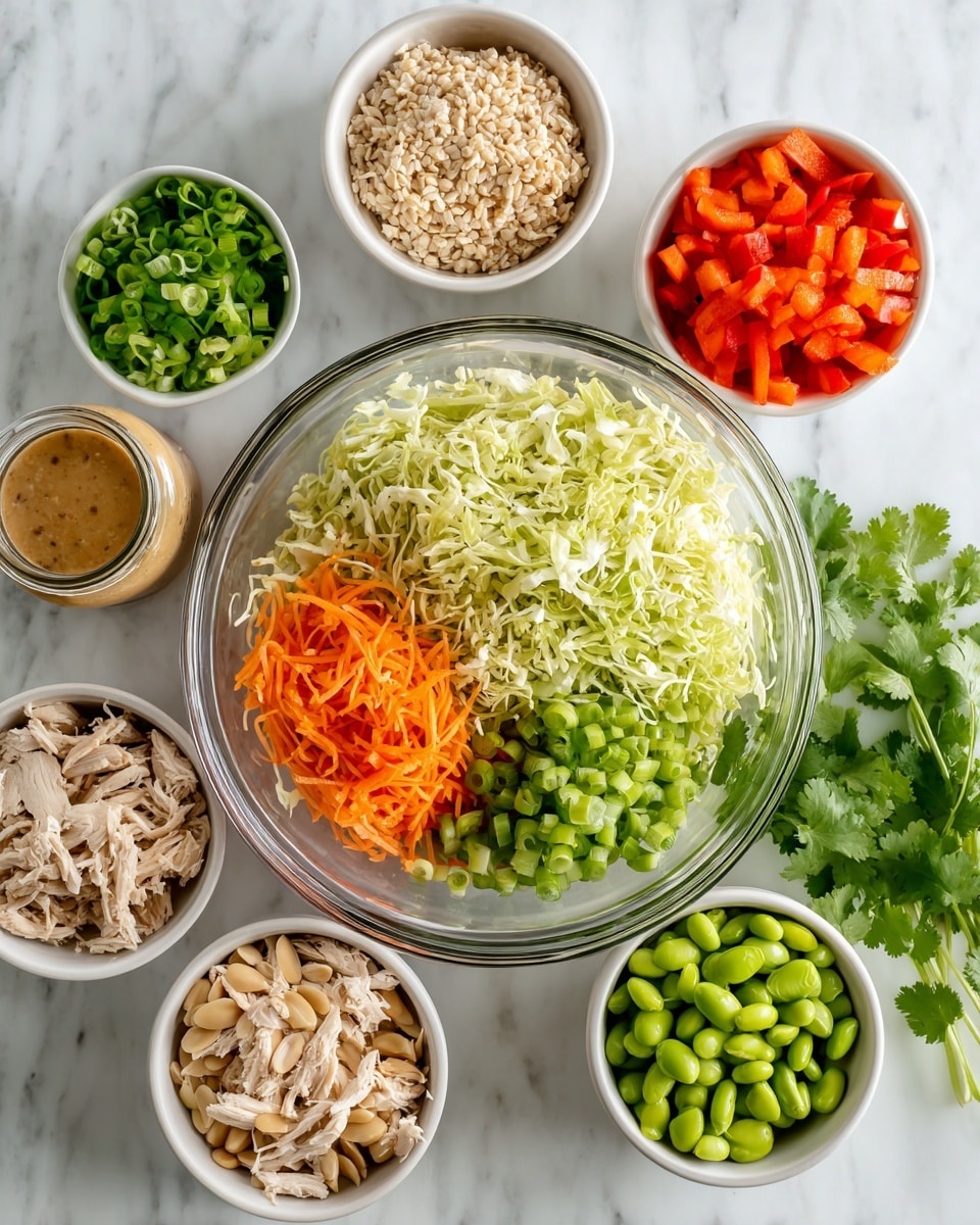 A clear glass bowl filled with two halves of shredded lettuce, one side light yellow and the other side green, is centered on a white marbled surface. Surrounding the main bowl are five smaller white bowls, each holding different ingredients: thinly shredded orange carrots, chopped red bell peppers, sliced green onions, shredded light beige chicken pieces, bright green edamame beans, and sliced light brown almonds. In the middle front, there is a small glass jar containing a light brown sesame dressing, and to the left, a spice jar with sesame seeds. Fresh green cilantro leaves are placed to the right side outside the bowls. Photo taken with an iphone --ar 4:5 --v 7