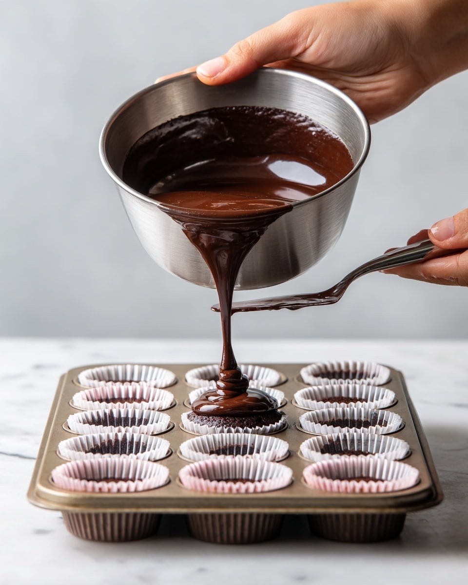 A woman's hand is holding a metal bowl tilted to pour smooth dark chocolate batter onto a cupcake tray filled with white and pink cupcake liners. Another woman's hand is holding a spatula with some batter on it inside the bowl. The cupcake tray sits on a white marbled surface. The image focuses closely on the pouring action, showing the shiny texture of the chocolate batter flowing into the liners. photo taken with an iphone --ar 4:5 --v 7