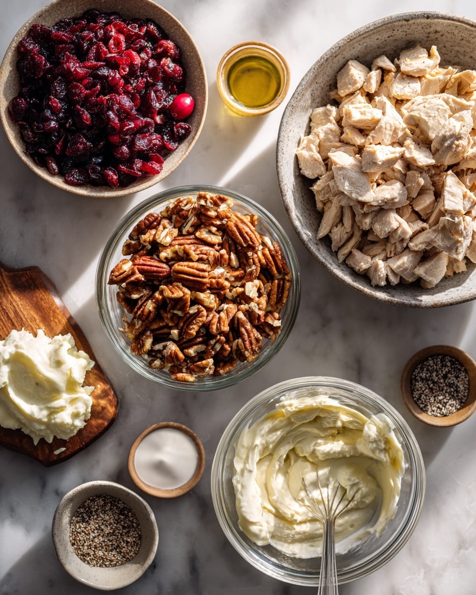 A white bowl filled with a creamy, chunky salad sits on a white marbled surface. The salad is thick and white with visible small pieces of red onions, dried cranberries, and crunchy brown nuts spread throughout. Around the main bowl, there are smaller white bowls holding whole dried cranberries and pecan nuts, along with a plate of fresh green lettuce leaves and white crackers with black sesame seeds. The overall scene is bright and fresh, highlighting the salad's creamy texture and scattered colorful bits. photo taken with an iphone --ar 4:5 --v 7