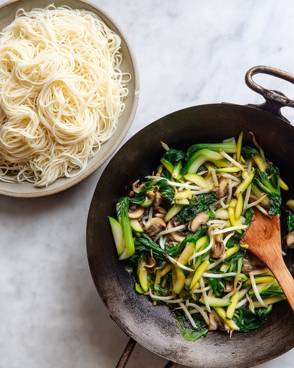 The left side shows a close-up of soft white noodles, tangled and smooth, filling the entire space with their shiny texture. On the right side, a dark metal wok sits on a white marble surface, filled with colorful cooked vegetables: bright green bok choy leaves and stems, pale bean sprouts, light beige mushroom slices, and green zucchini pieces with darker edges mixed evenly. A wooden spoon with a light brown handle rests inside the wok, blending with the natural colors of the vegetables. photo taken with an iphone --ar 4:5 --v 7