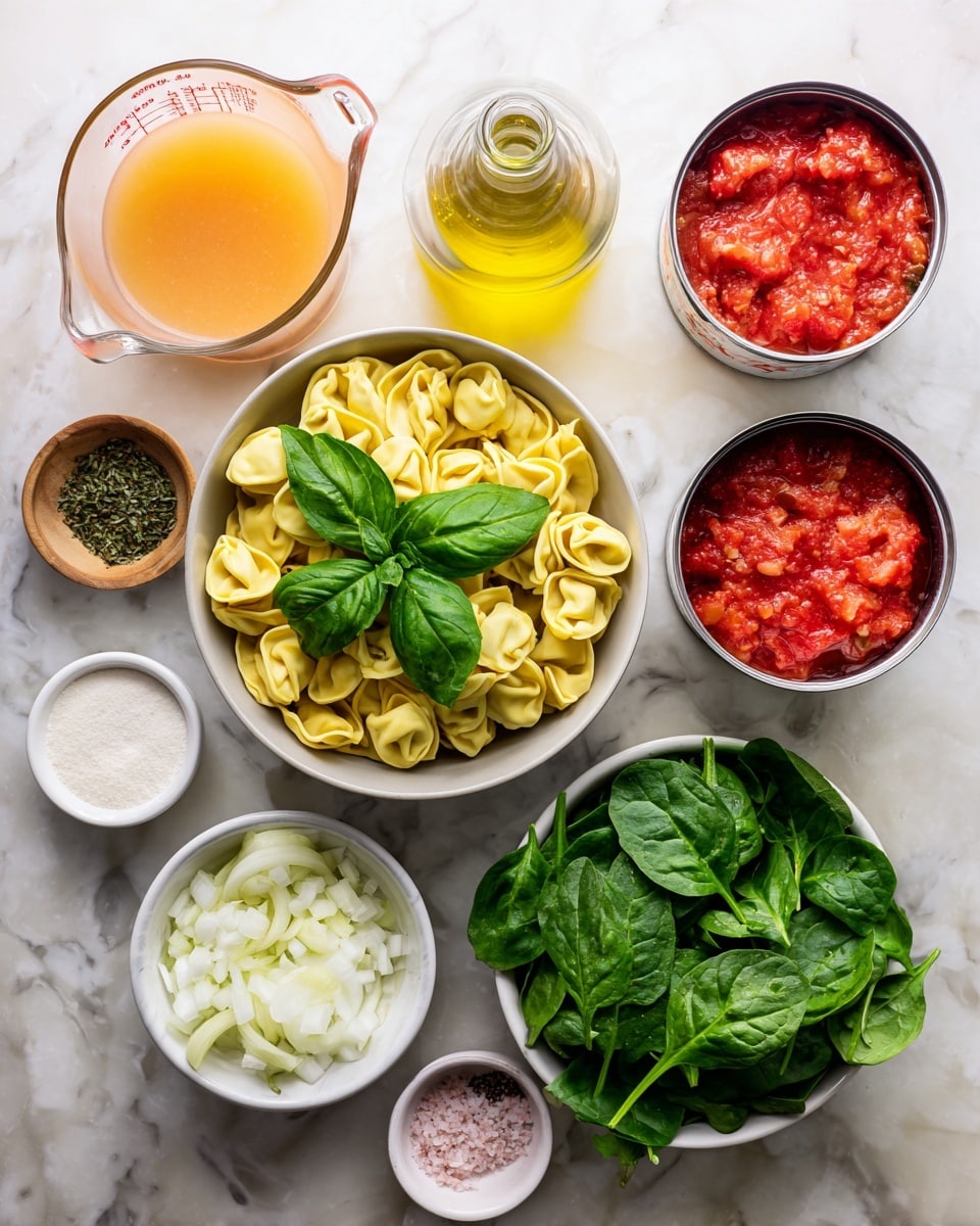 The image shows a top view of several ingredients placed on a white marbled surface. In the center, there is a bowl filled with uncooked yellow tortellini pasta and fresh green basil leaves on top. To the upper left of the bowl, there is a glass measuring cup filled with light orange broth. Near it, a glass bottle with yellow oil is placed. To the right of the bowl, two open white cans contain crushed red tomatoes with a thick texture. Below the cans, a small light brown bowl holds dried green herbs, and below this, a white bowl contains finely chopped white onions. At the bottom left corner, there are small bowls with white powder, minced garlic, and a container with white cream. Near the lower center is a white bowl full of fresh green spinach leaves. Finally, a small bowl near the bottom right contains pink salt and black pepper. The photo taken with an iphone --ar 4:5 --v 7
