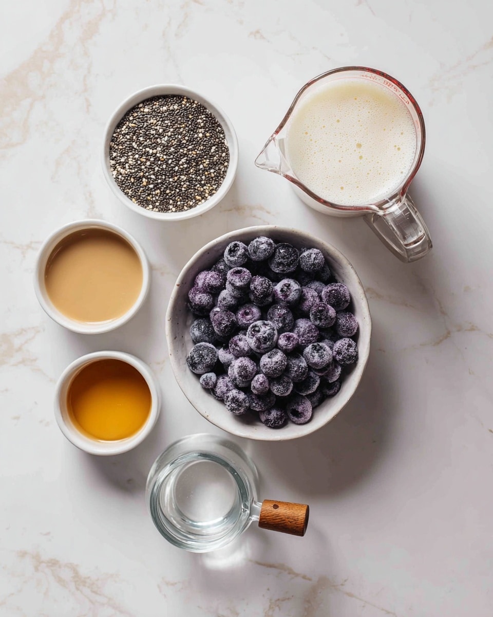 The image shows a top view of different ingredients on a white marbled surface, arranged in small white bowls and glass containers. In the center, there is a white bowl filled with dark purple frozen blueberries that have a frosty look. Above it to the left, there is a white bowl filled with small black and white chia seeds. Above to the right, a clear glass measuring cup holds a foamy white liquid. Below that, a small clear glass cup contains a small amount of light beige liquid with a wooden handle. Around the bowls, there are three small white bowls filled with a golden brown liquid, and a small clear glass bowl with a little water. The setup is clean and organized, with a light, fresh feeling. photo taken with an iphone --ar 4:5 --v 7