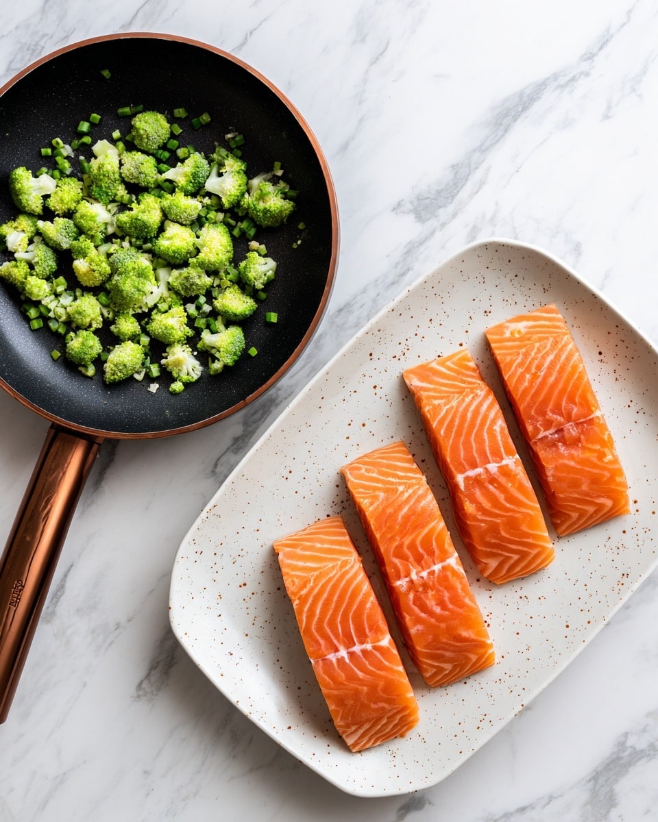 The image shows two parts: on the left is a black frying pan with a brown handle, filled with small green broccoli pieces scattered inside, placed on a white marbled surface. On the right is a white plate with small brown speckles, holding four raw salmon fillets arranged side by side in a neat line, showing a rich orange color with subtle white lines on top. Photo taken with an iphone --ar 4:5 --v 7