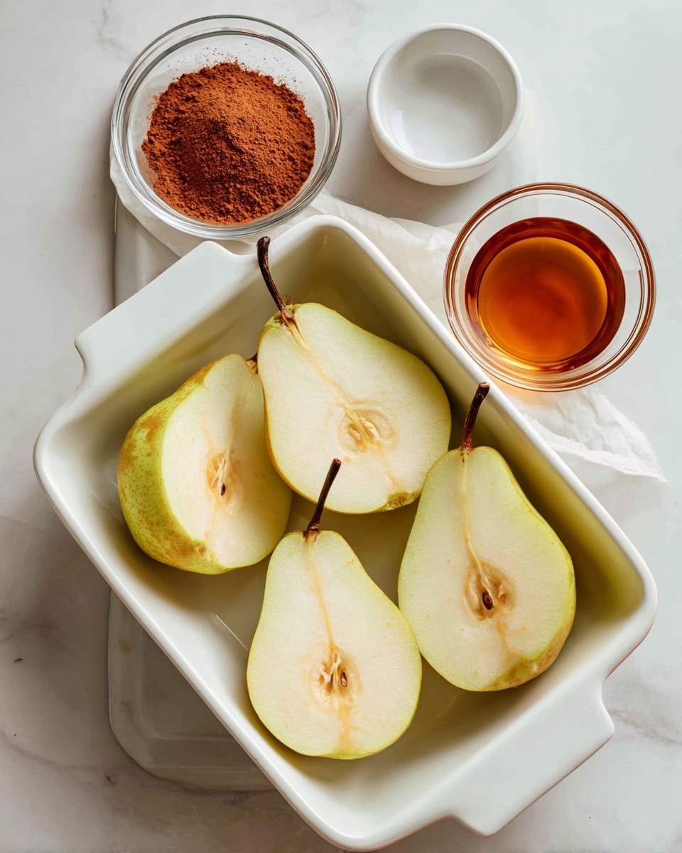 A white rectangular baking dish holds four pear halves, each cut side up, showing their smooth, pale flesh with light greenish tones near the skin and a round core area in the center. The pears have light brown skin edges and dark brown stems. To the top right of the dish, there is a small clear glass bowl filled with a reddish-brown powder, and next to it, a small white bowl contains a dark amber liquid. All items are placed on a flat white marbled surface. Photo taken with an iphone --ar 4:5 --v 7