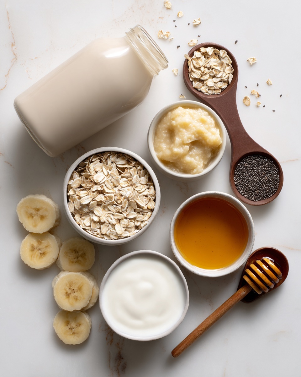 A white marbled surface holds a clear glass bottle filled with light beige liquid lying down on its side. Around it, there are four white bowls: one filled with pale yellow mashed banana, one with dry rolled oats, another with creamy white yogurt, and the last one holding golden honey with a honey dipper resting on its edge. Two brown measuring spoons, one filled with dark brown liquid and the other with black chia seeds, are placed near the bowls. Three slices of banana are scattered near the measuring spoons. The clean, bright layout shows natural ingredients in simple white containers. Photo taken with an iphone --ar 4:5 --v 7