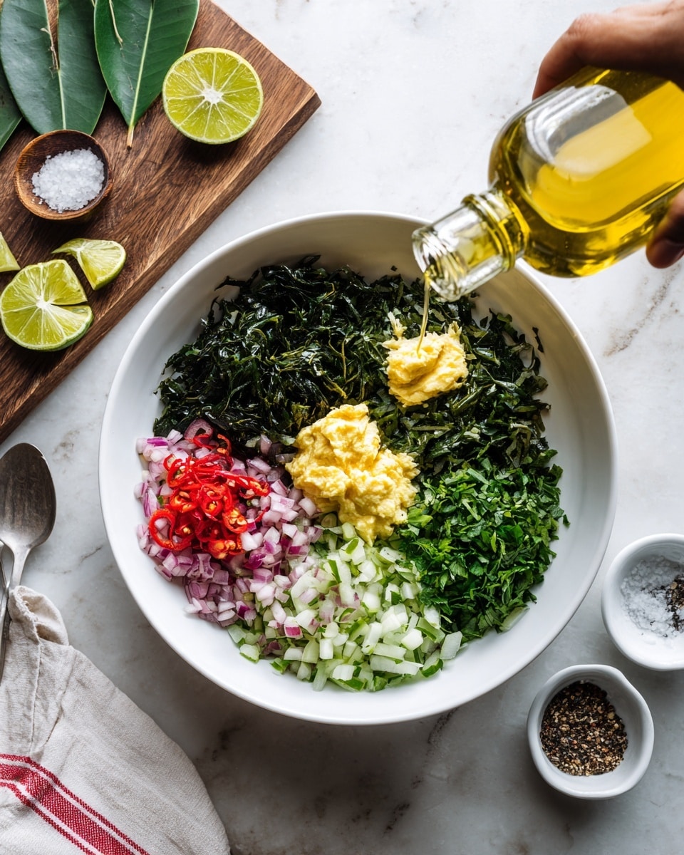A white bowl on a white marbled surface holds seven separate layers of chopped ingredients arranged in a circle. Starting from the top and going clockwise: finely chopped dark green herbs with a slightly wilted texture, two dollops of light yellow paste, finely chopped light green onion rings, a small pile of chopped red chilies mixed with green herbs, finely chopped fresh green herbs, finely chopped pale purple shallots with some seasoning, and finely chopped medium green herbs. A woman's hand is pouring golden olive oil over the layers from a clear bottle. Around the bowl, there is a lime sliced in half, some green leaves on a wooden board, and small white bowls containing coarse salt and black pepper. A white and red striped cloth and a spoon rest nearby. Photo taken with an iphone --ar 4:5 --v 7