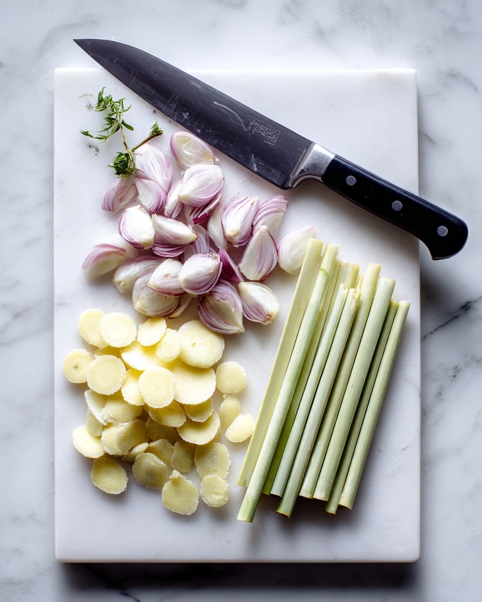 A white cutting board on a white marbled surface holds several pieces of cut ingredients arranged in groups. There are light purple and white shallot quarters on the left, small round slices of pale yellow ginger near the top center, and several pale green lemon grass stalk segments on the right. A large kitchen knife with a black handle lies horizontally above the ingredients on the board. The photo taken with an iphone --ar 4:5 --v 7